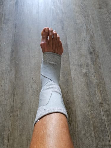 Customer wearing the light grey, adjustable Premium Bamboo Ankle Support on their foot.