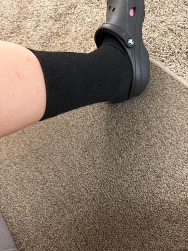 Customer wearing the black Anti-Fatigue Bamboo Footsleeve inside a black clog-style shoe.
