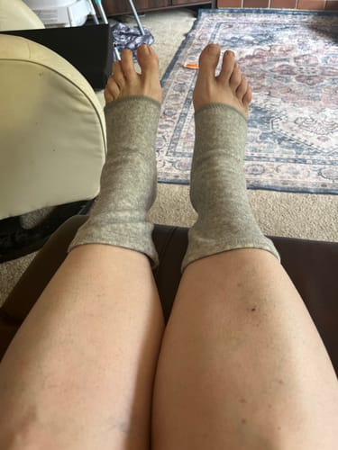 Customer's grey bamboo footsleeves worn on both feet, showing the fit around the arches and ankles.