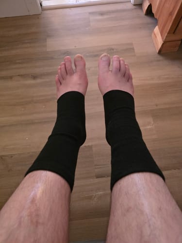 Customer's view looking down at their feet wearing the black Bamboo Footsleeves.