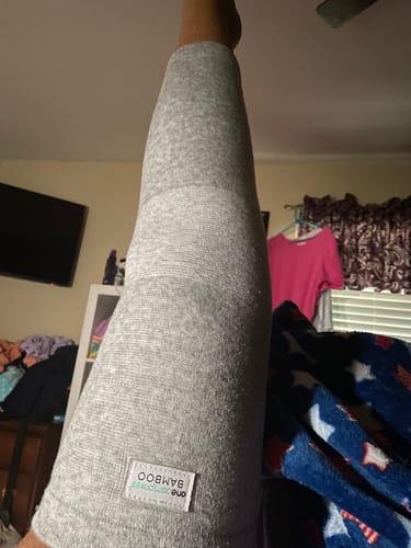 Reviewer's gray Bamboo Leg Sleeve worn on their leg, showing the soft, textured material and brand label.