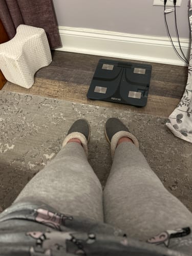 Customer's legs wearing the comfortable Bamboo Leg Sleeve, shown while relaxing in grey loungewear.