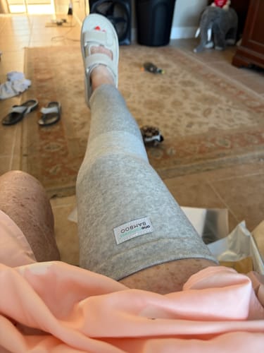 Reviewer relaxing with their leg propped up, wearing the grey full-length Premium Bamboo Leg Sleeve.