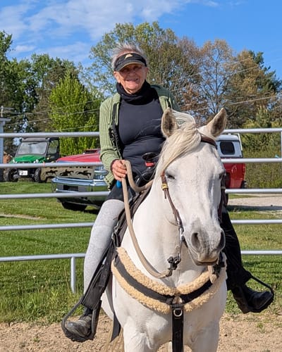 Reviewer wearing the Premium Bamboo Leg Sleeve for support while riding a white horse.