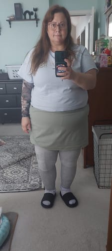 Reviewer standing while wearing the full-length Premium Bamboo Leg Sleeves on both legs under a skort.