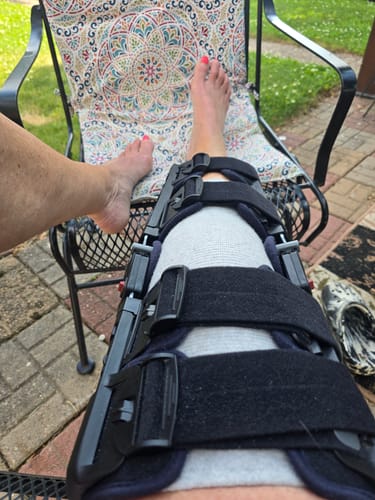 Customer wearing the Premium Bamboo Knee Sleeve for compression underneath a larger, more rigid knee brace.