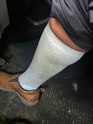 Customer wearing a light gray Premium Bamboo Compression Sock on their lower leg.