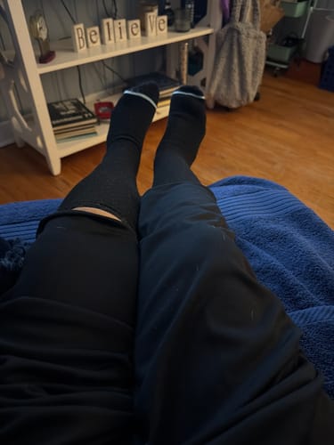 Reviewer relaxing with feet up, wearing the black Premium Bamboo Compression Socks.