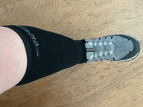 Customer's leg seen from above wearing a black Premium Bamboo Compression Sock with a gray athletic shoe.