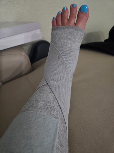 Reviewer's foot wearing the grey Premium Bamboo Ankle Support while resting and recovering.