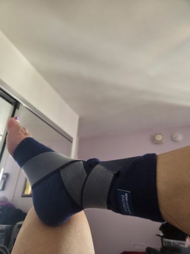 Reviewer's foot wearing the blue and grey Premium Bamboo Ankle Support, showing the adjustable compression straps.