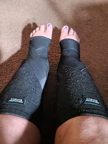 Customer's feet wearing black Premium Bamboo Ankle Supports, shown from above.