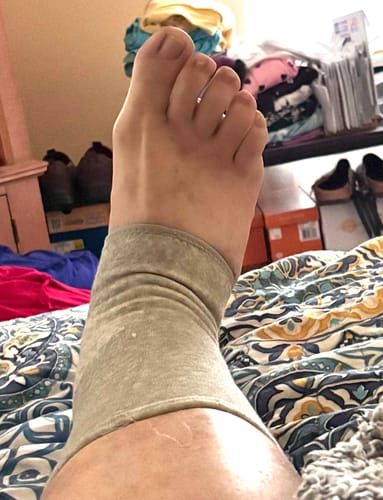 Customer wearing a tan Anti-Fatigue Bamboo Footsleeve, showing its snug fit.