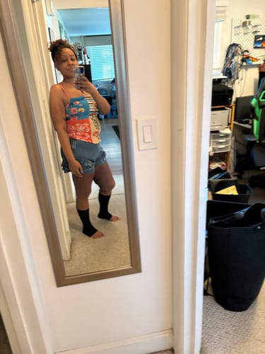 Customer taking a mirror selfie while wearing the black anti-fatigue bamboo footsleeves.