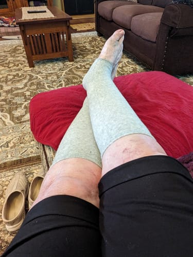 Customer relaxing with their feet up, wearing the grey Bamboo Footsleeves.