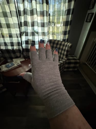 Customer wearing a grey, fingerless Premium Onecompress™ Glove on their hand indoors.