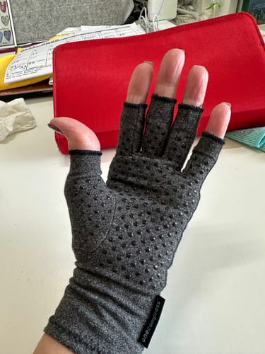 image 2 out of 2: Reviewer showing the palm of the grey Onecompress™ Glove, highlighting the grip dots.