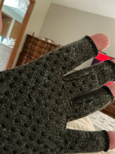 Close-up of a reviewer's hand wearing the dark grey, fingerless Premium Onecompress™ Gloves with grip dots.
