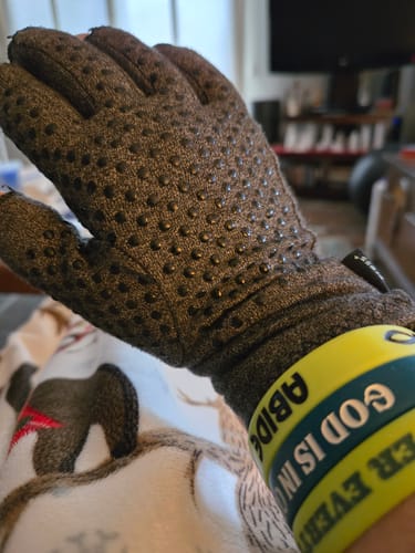 Close-up of a reviewer's hand wearing the dark Onecompress glove, showing the dotted grip texture on the palm.