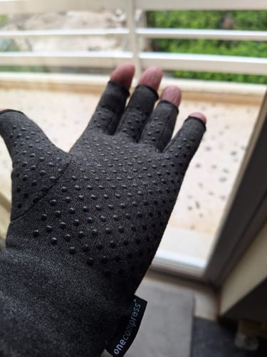 image 2 out of 2: Customer showing the palm of the Onecompress Glove, highlighting the black grip dots.
