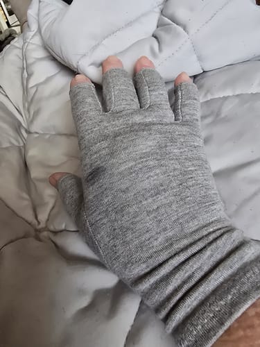 Customer's hand wearing a grey, open-fingered Premium Onecompress™ Glove, covering the hand and wrist.