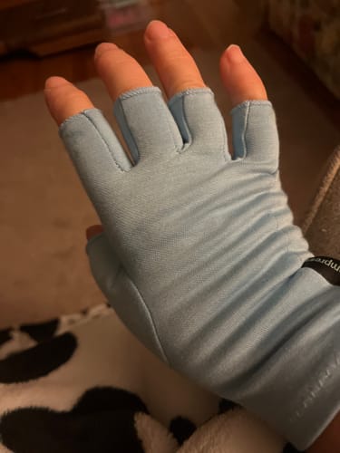 Customer's hand wearing a light blue, fingerless Onecompress™ Glove indoors.