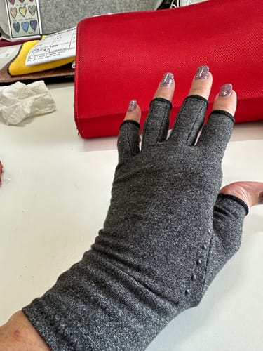 Reviewer showing the back of their hand in a comfortable grey Onecompress™ Glove.