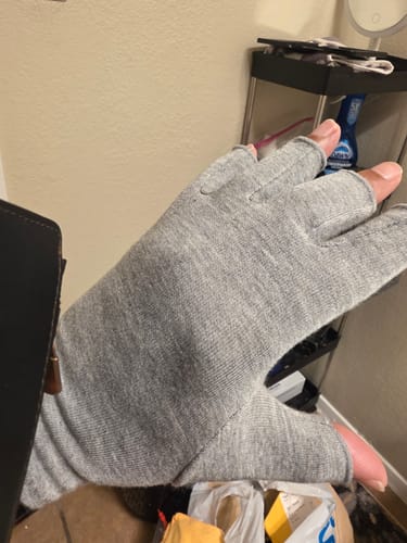 Customer wearing the grey, fingerless Onecompress™ Gloves on both hands in an indoor setting.