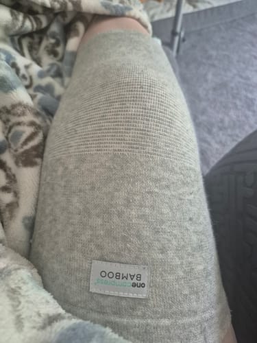 Customer's gray Bamboo Leg Sleeve worn on a knee, showing a fabric texture and brand label.