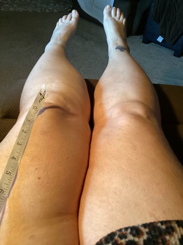 image 2 out of 2: Customer measuring their bare thigh with a tape measure, likely for sizing the Premium Bamboo Leg Sleeve.