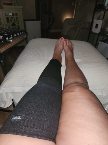 Customer's legs are shown side-by-side, with one leg wearing the full-length dark Premium Bamboo Leg Sleeve.