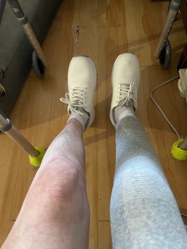 Customer's gray Premium Bamboo Leg Sleeve worn on one leg while standing with a walker.