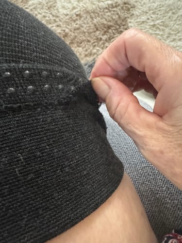 image 2 out of 2: Customer's hand pulling at the unraveling thread on the Premium Bamboo Leg Sleeve's top hem.