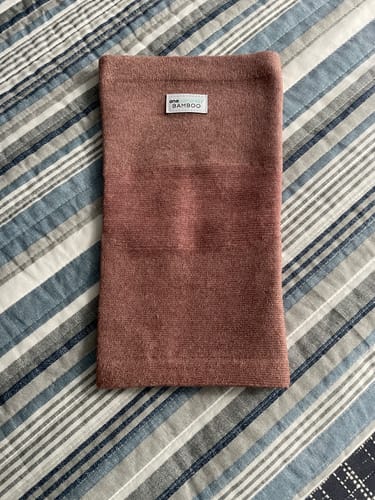 image 2 out of 2: Customer's pink Premium Bamboo Knee Sleeve laid flat on a striped bedspread.