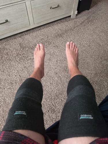 Customer's point-of-view showing them wearing the dark Premium Bamboo Knee Sleeves on both knees.