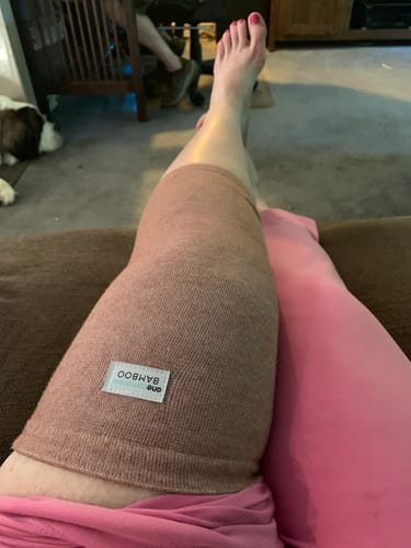 Reviewer wearing the comfortable Premium Bamboo Knee Sleeve while resting their leg on a couch.