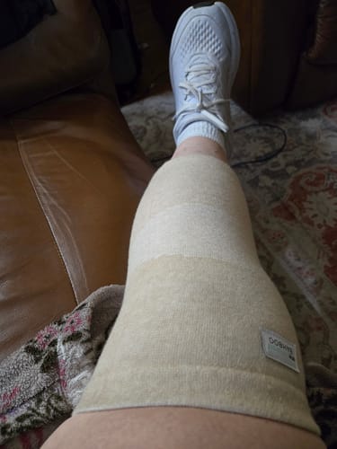 image 2 out of 2: A different angle showing the reviewer's leg propped up with the beige Premium Bamboo Knee Sleeve.