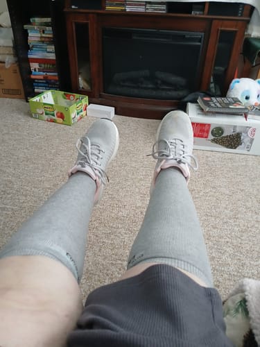 Reviewer's perspective looking down at their legs, wearing the grey Premium Bamboo Compression Socks and sneakers.