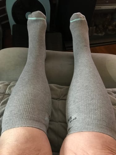Reviewer relaxing with their feet up while wearing the grey Premium Bamboo Compression Socks.