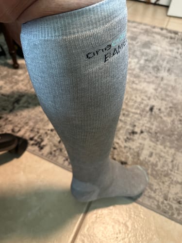 Customer's leg wearing the light grey Premium Bamboo Compression Socks, showing the fit.