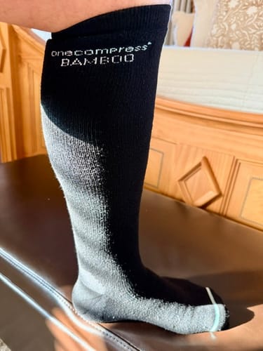 Reviewer showing the fit of a black and grey Premium Bamboo Compression Sock on their leg.