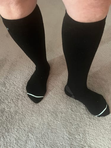 Customer standing in their black Premium Bamboo Compression Socks, showing the knee-high fit.
