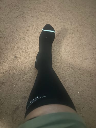 Reviewer's view looking down at their leg wearing a black Premium Bamboo Compression Sock.